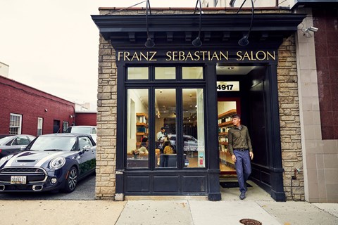 a man is standing in front of a salon