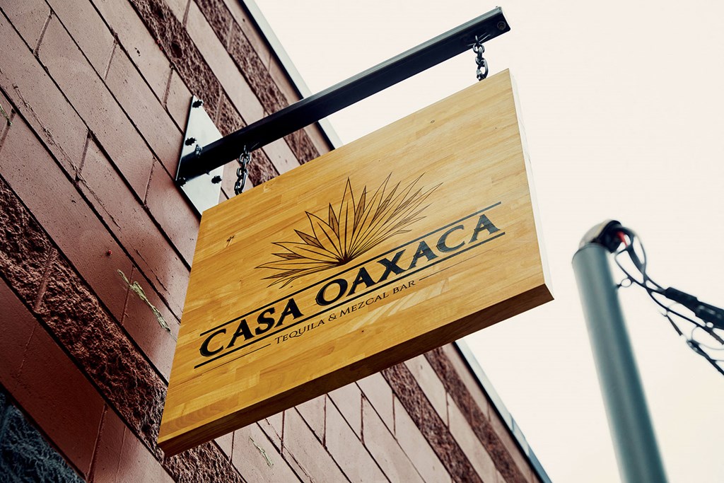 a wooden sign oaxaca on a brick building