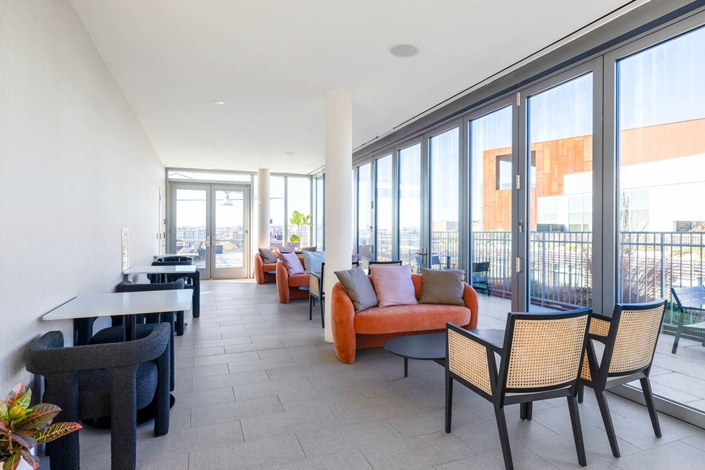 a living room with orange furniture and large windows
