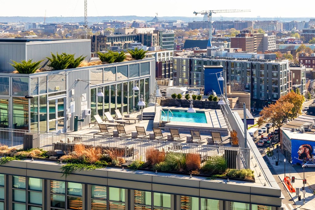 a roof terrace with a pool and a view of the city