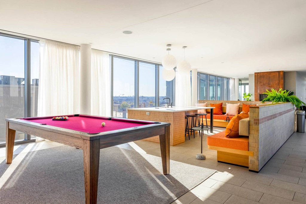 a pool table in a living room with a bar and a view