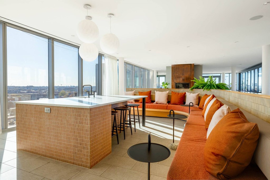 a kitchen and living room with orange couches and a counter