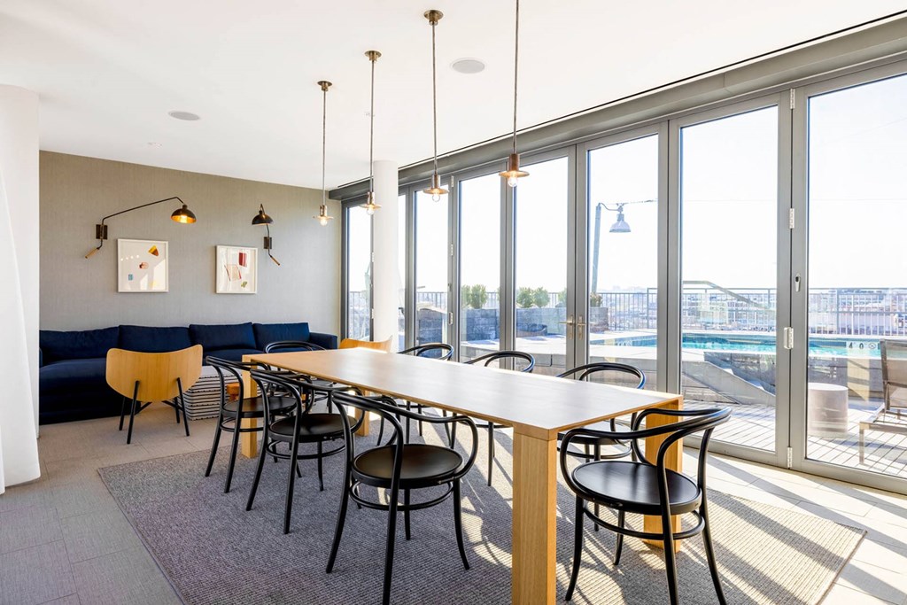 a large table and chairs in a room with large windows