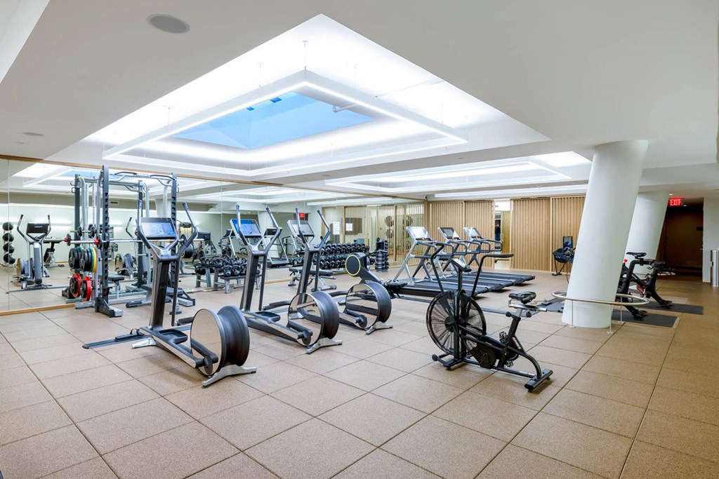a gym full of exercise equipment in the lobby of a building