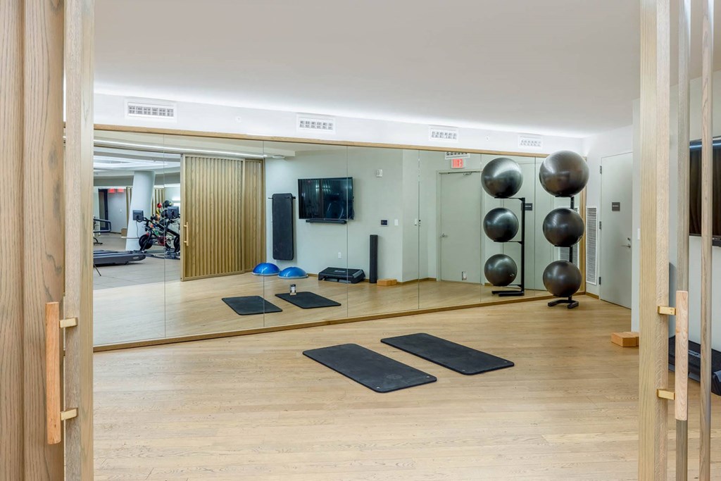 a yoga room with mirrors and mats on the floor
