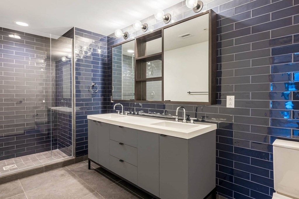 a bathroom with a sink and a shower and a mirror