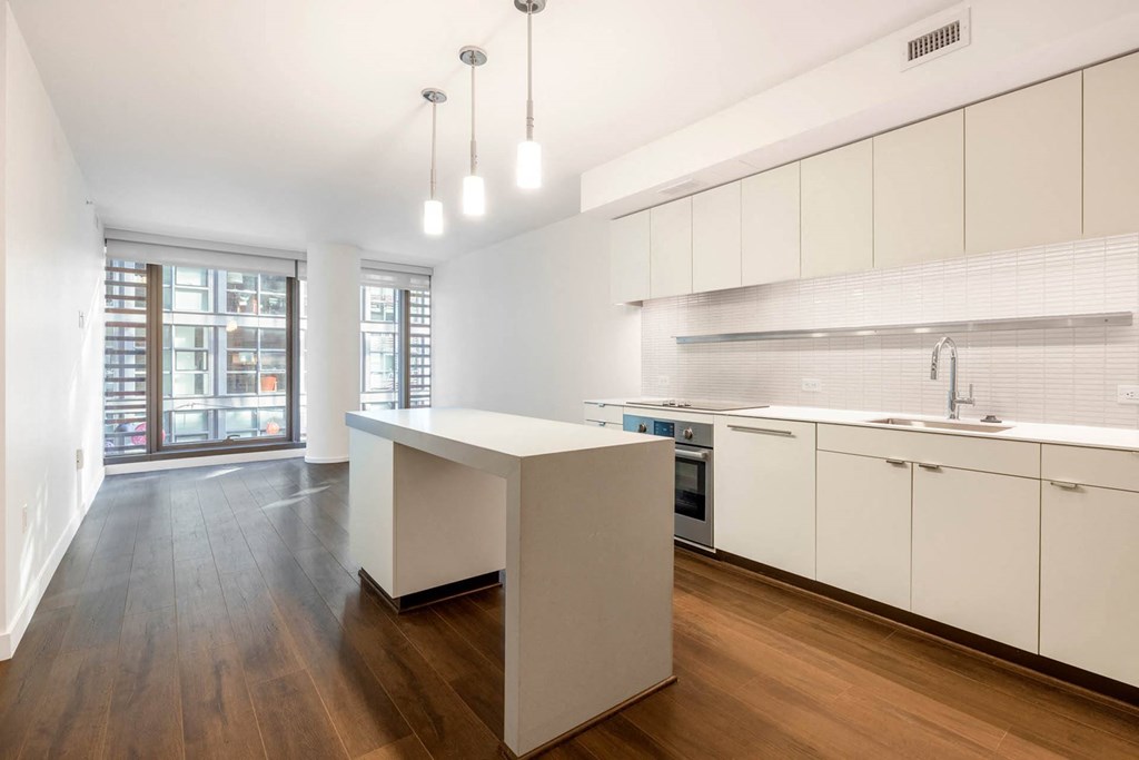 a white kitchen with a white island and a window