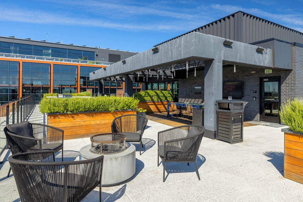 a patio with chairs and tables outside of a building