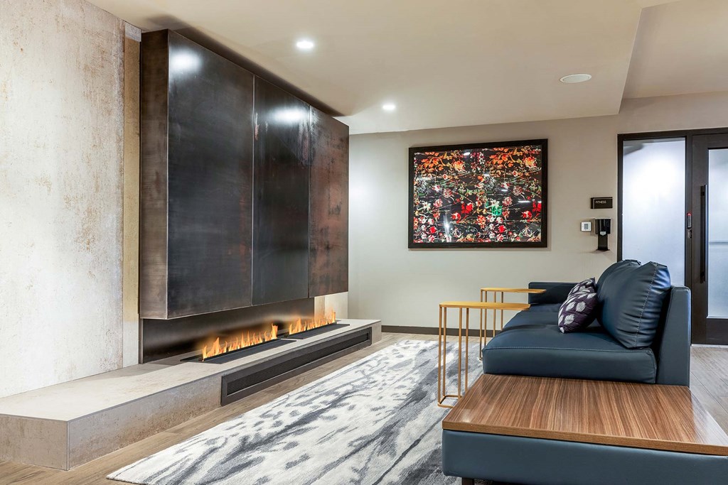 a living room with a black couch and a fireplace