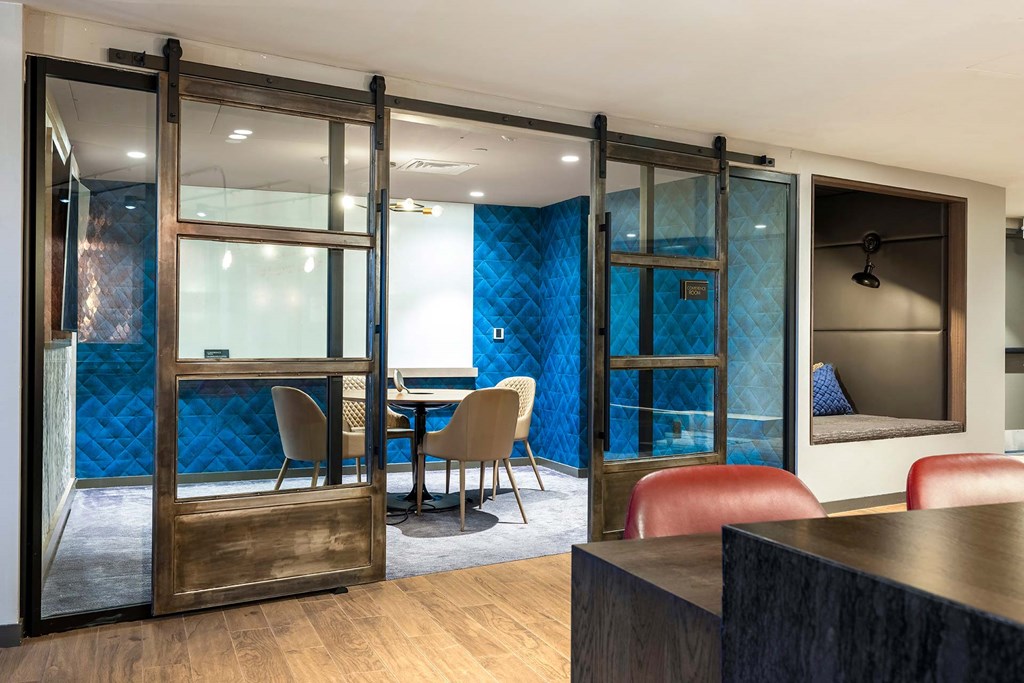 a conference room with a table and chairs and sliding glass doors