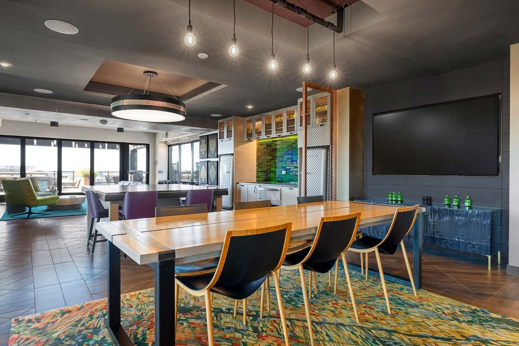 a conference room with a table and chairs and a television