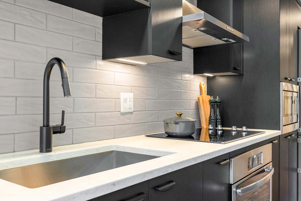 a black and white kitchen with a sink and a stove