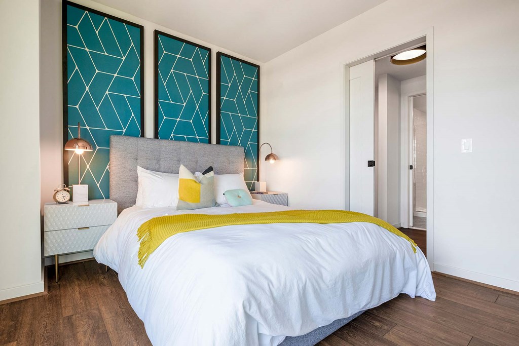 a bedroom with a white bed and a blue accent wall