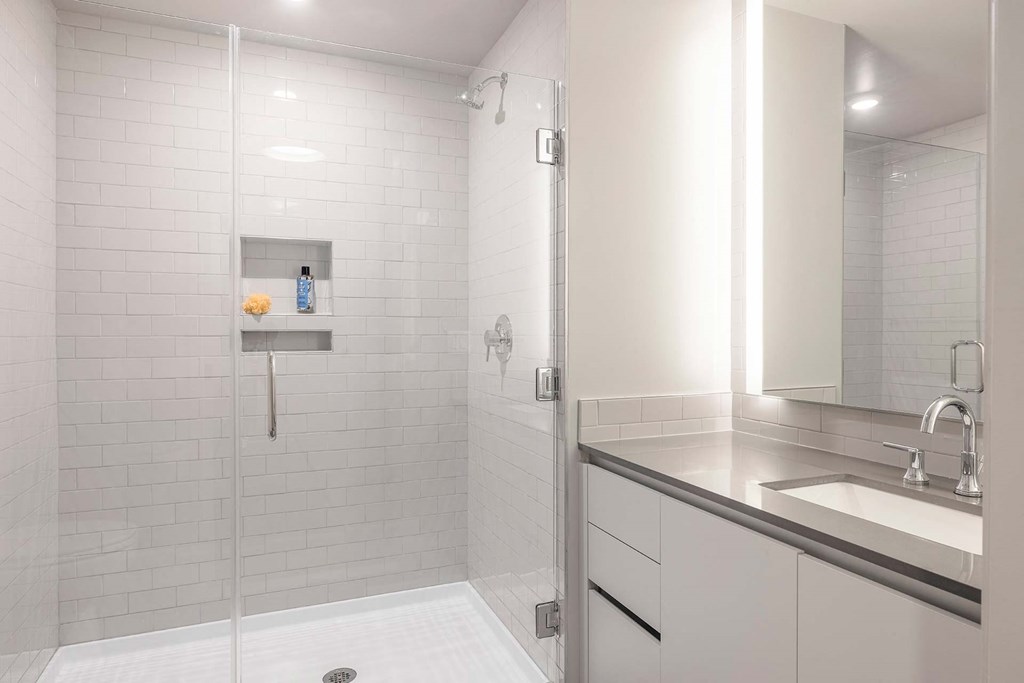 a white bathroom with a shower and a sink