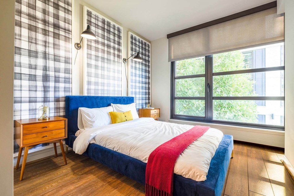 a bedroom with a bed and a large window