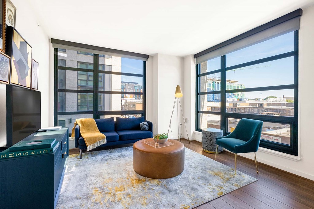 a living room with large windows and a blue couch
