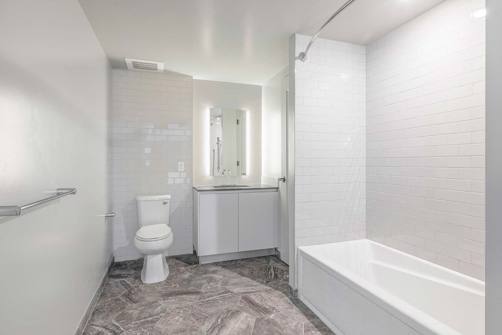 a white bathroom with a toilet and a tub