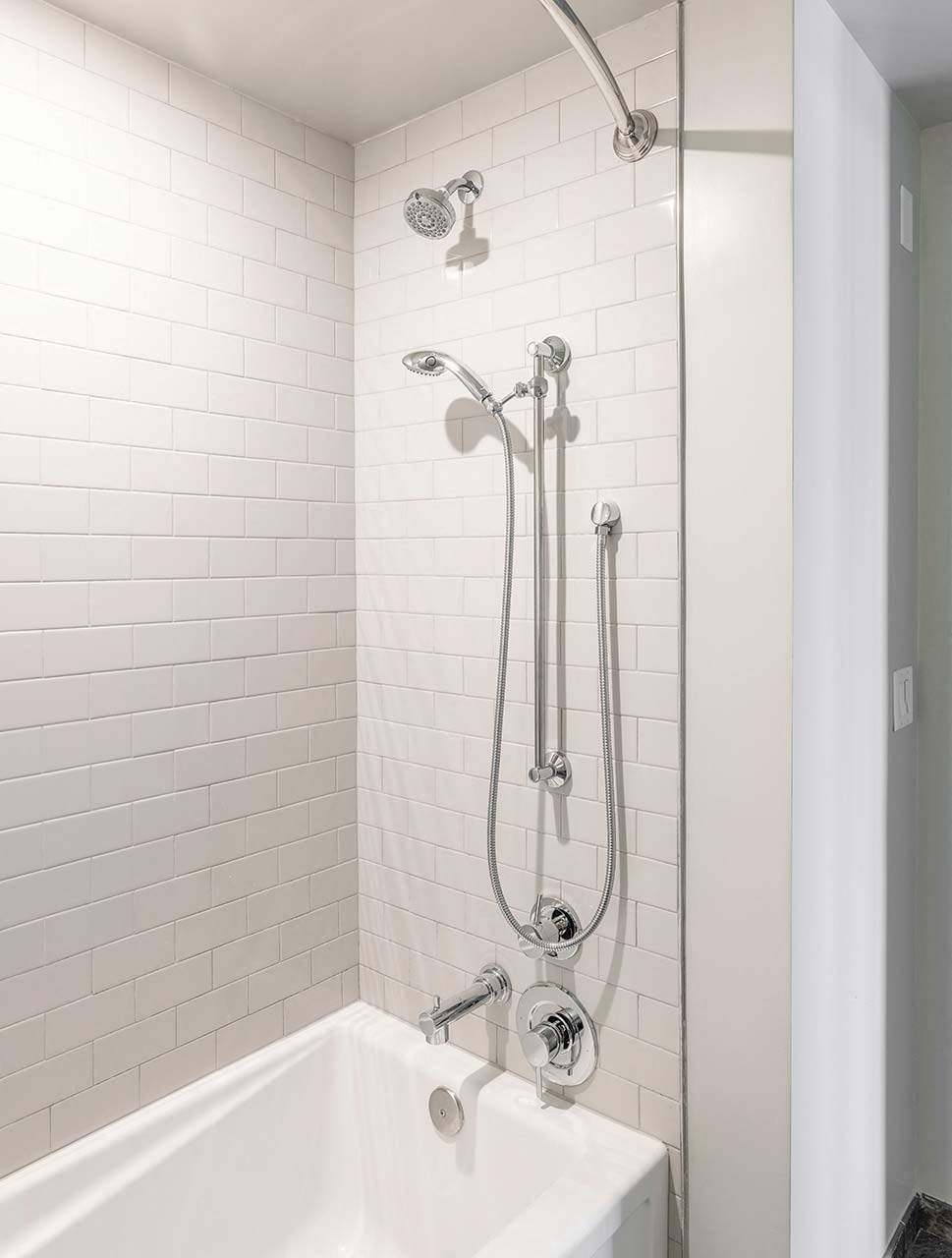 a white bathroom with a shower and a tub