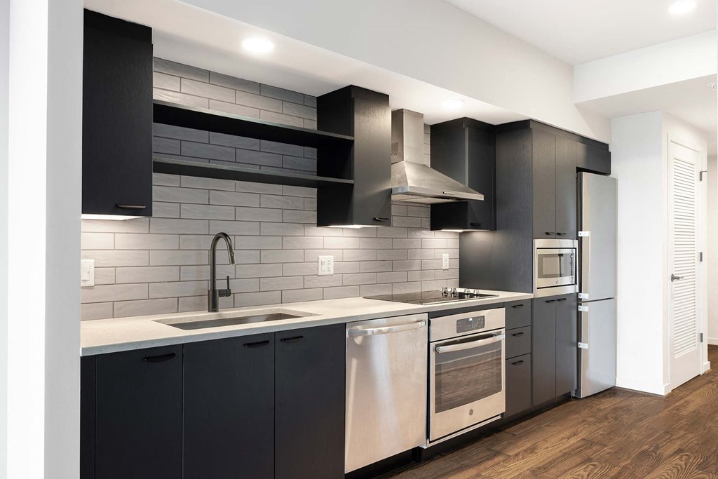 a modern kitchen with black cabinets and stainless steel appliances