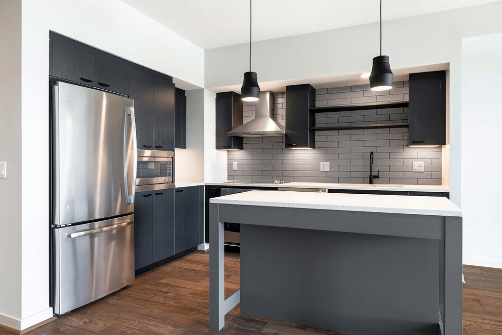 a kitchen with stainless steel appliances and black cabinets