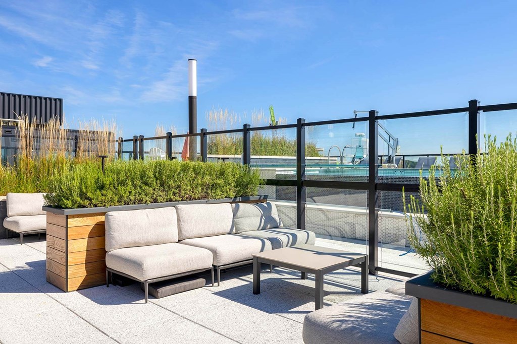 a rooftop patio with furniture and plants