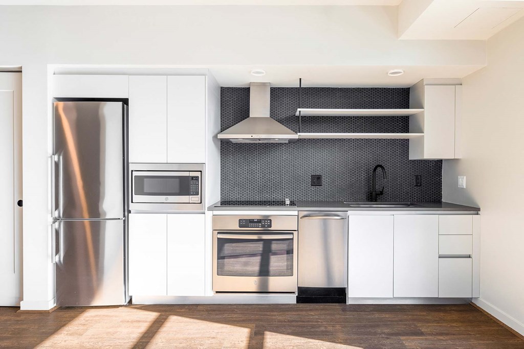 a white kitchen with stainless steel appliances and white cabinets