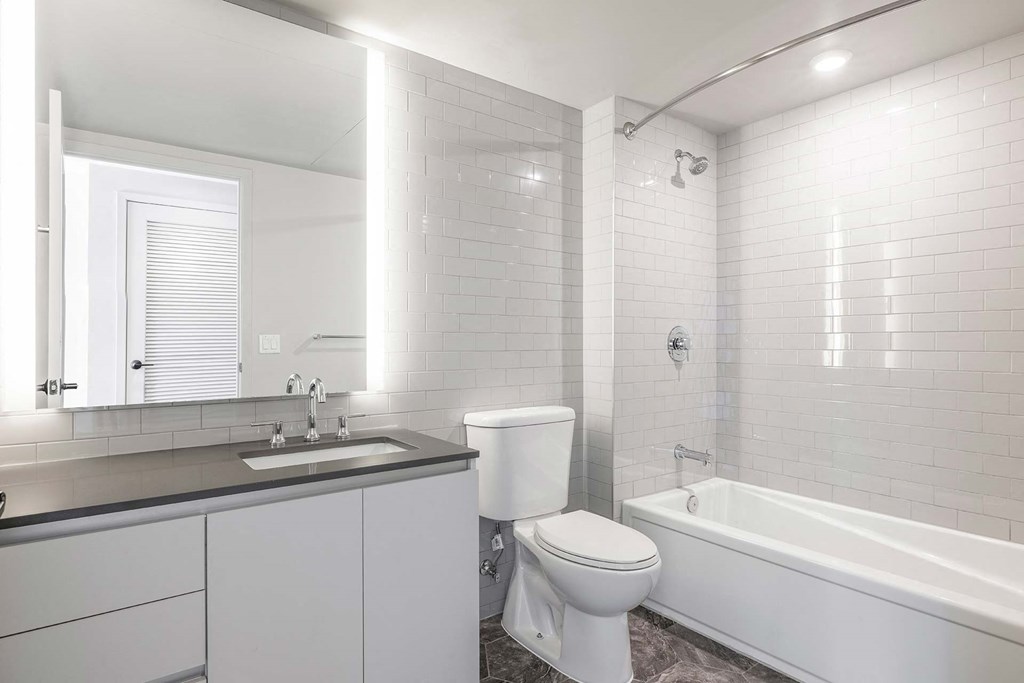 a white bathroom with a toilet sink and tub