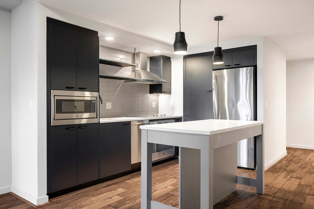 a kitchen with a white island and black cabinets