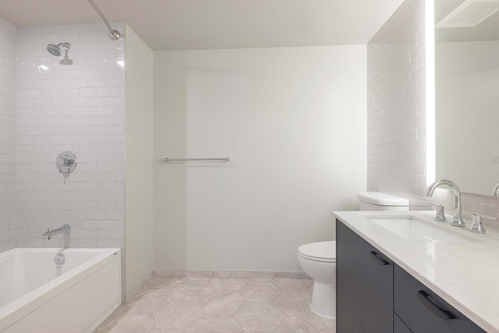 a white bathroom with a tub and a toilet and a sink