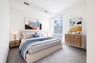 a bedroom with a large bed and two large paintings on the wall