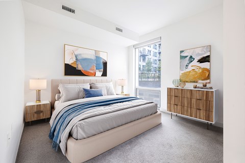 a bedroom with a large bed and two large paintings on the wall