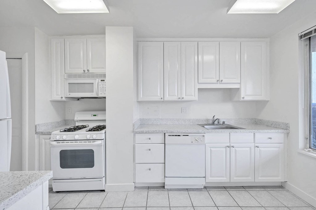 a white kitchen with white appliances and white cabinets