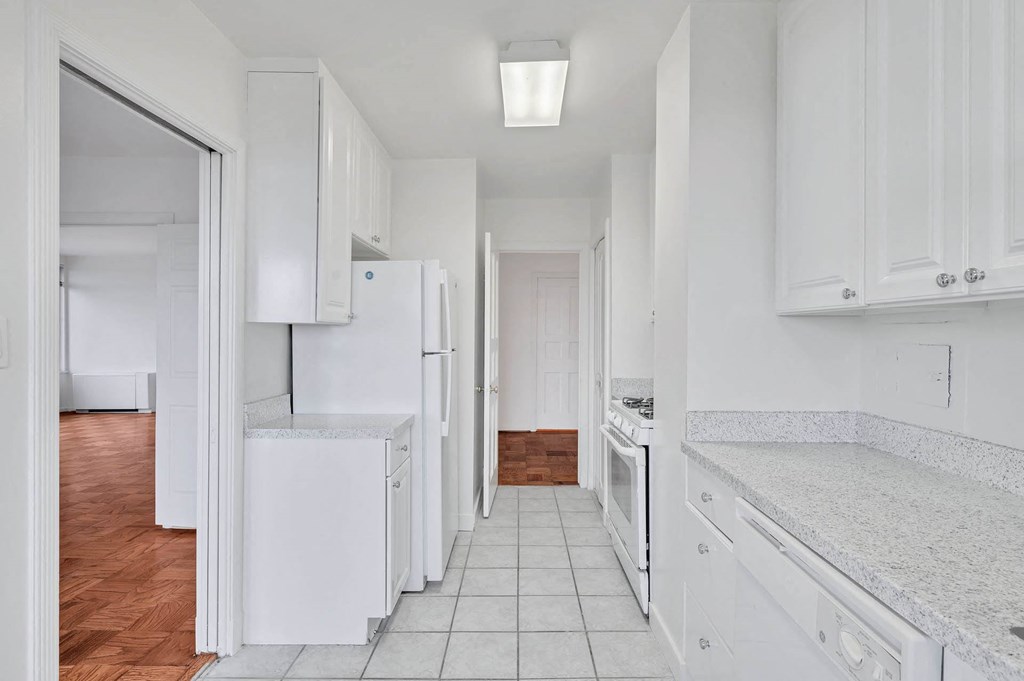 a white kitchen with white cabinets and white appliances