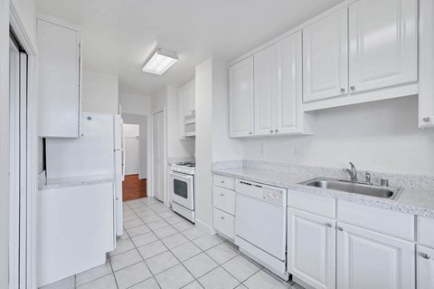 a white kitchen with white cabinets and white appliances