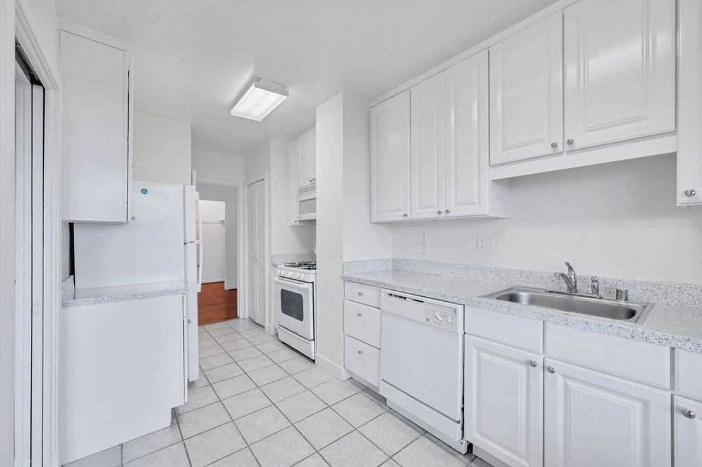 a white kitchen with white cabinets and white appliances