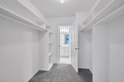 a bedroom with a closet and a door to a bathroom