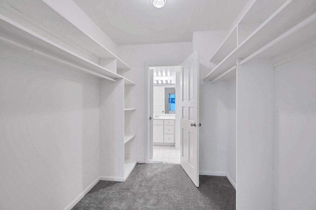 a bedroom with a closet and a door to a bathroom