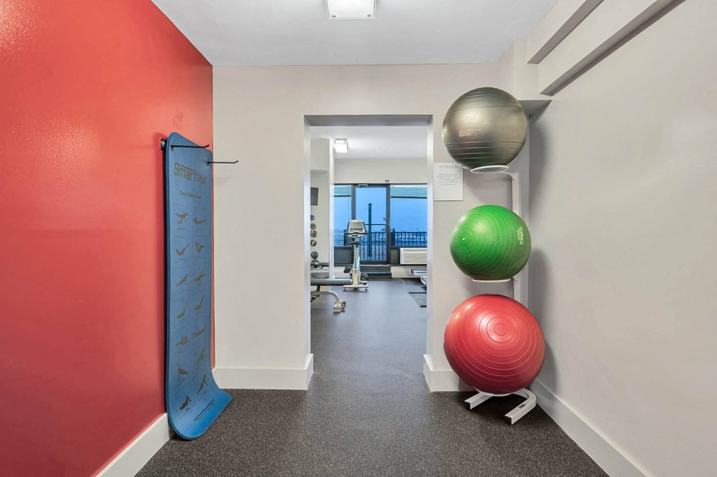 A hallway with a red wall, a blue wall, and a green exercise ball.