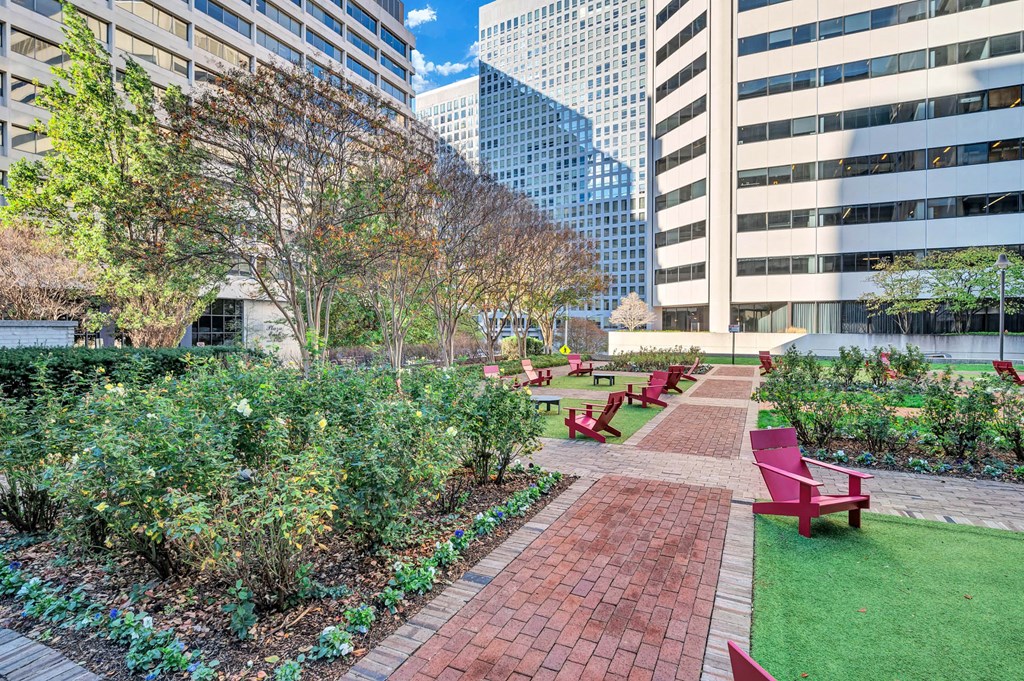 A park with red benches and green grass.
