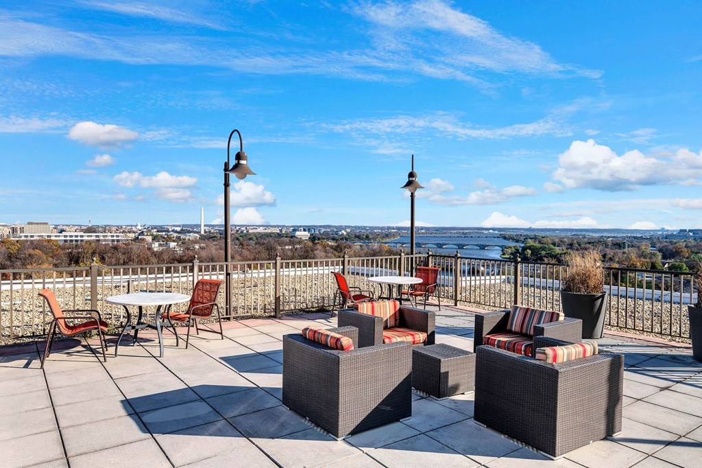 a rooftop patio with tables and chairs and a view of the city