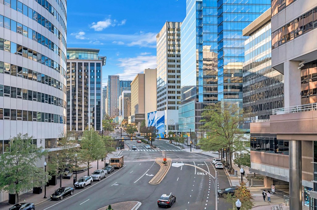 A city street with cars and buildings on either side.