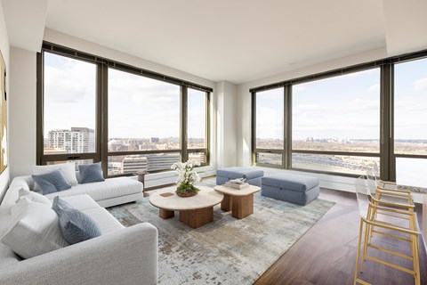 a living room with couches and a coffee table in front of large windows
