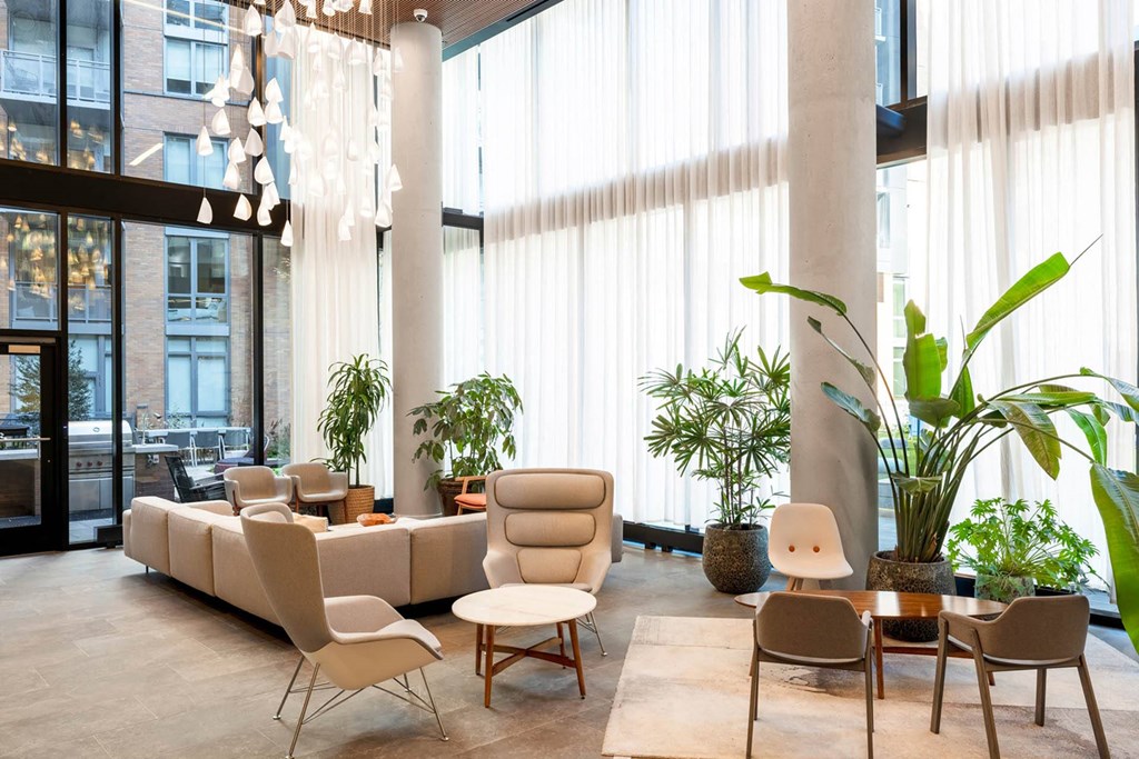 the lobby of a hotel with chairs and couches and plants
