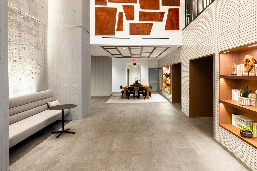 the lobby of the building has a long corridor with a table in the middle