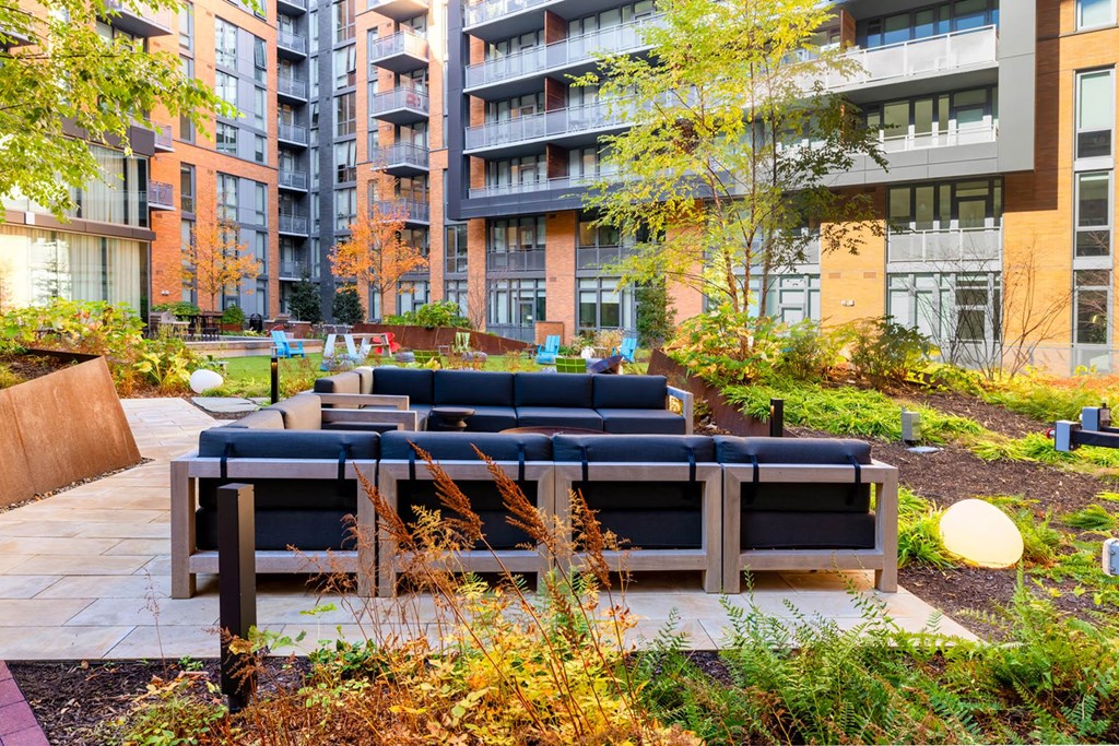an outdoor seating area with benches in front of an apartment building