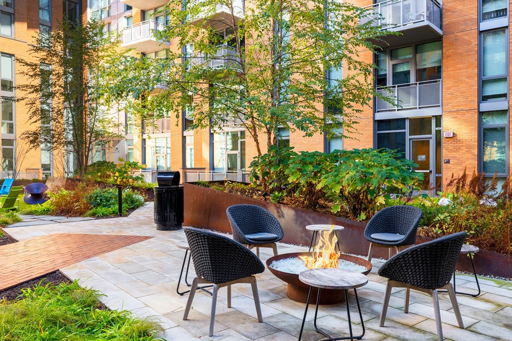 a courtyard with tables and chairs in front of an apartment building
