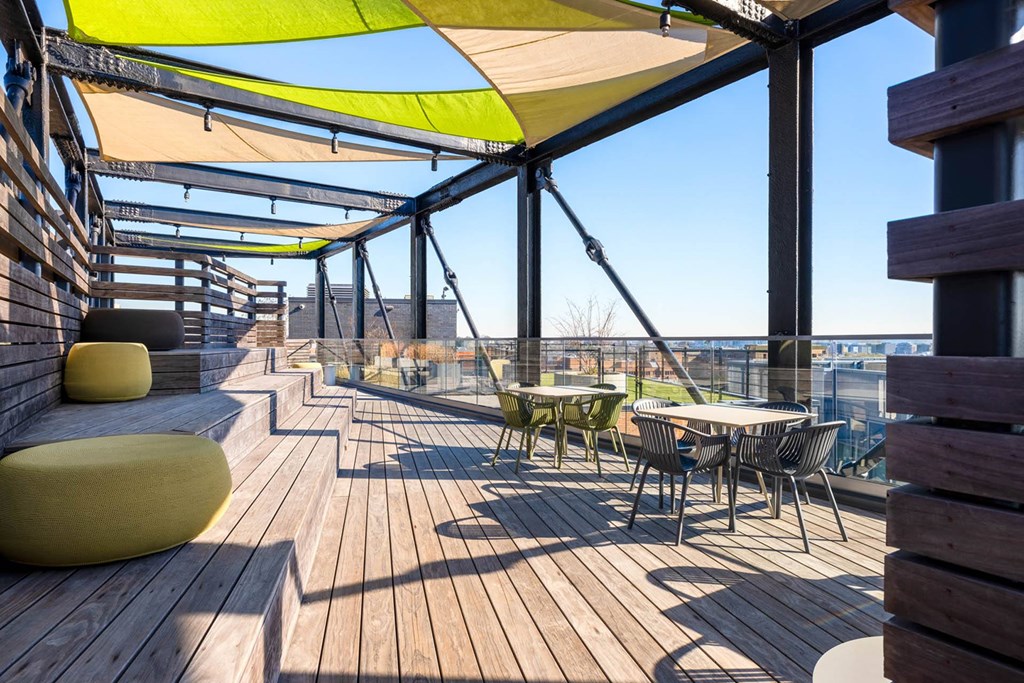 a roof deck with tables and chairs and a view