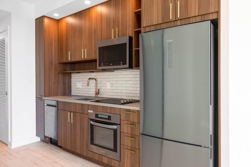 a kitchen with wooden cabinets and a stainless steel refrigerator