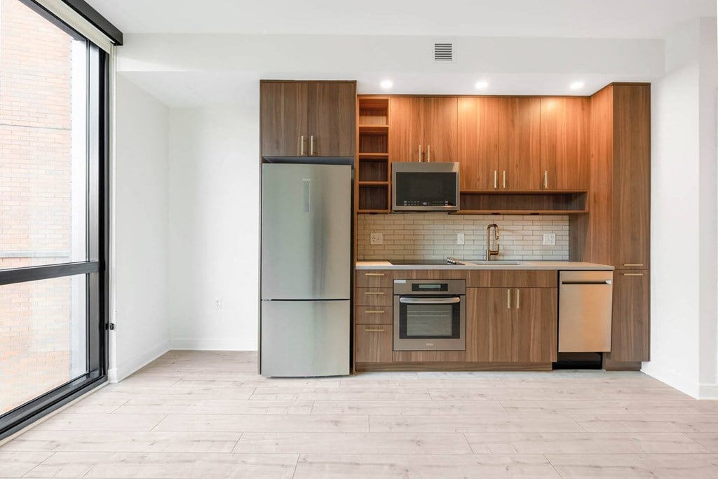 a kitchen with wooden cabinets and a stainless steel refrigerator