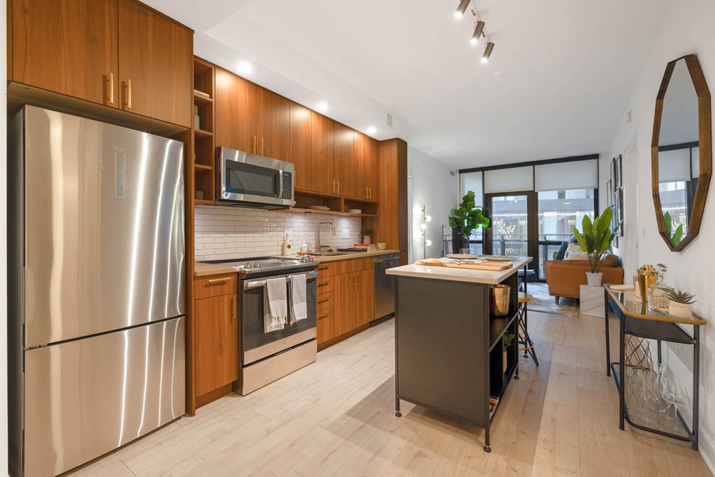 a large kitchen with stainless steel appliances and wooden cabinets
